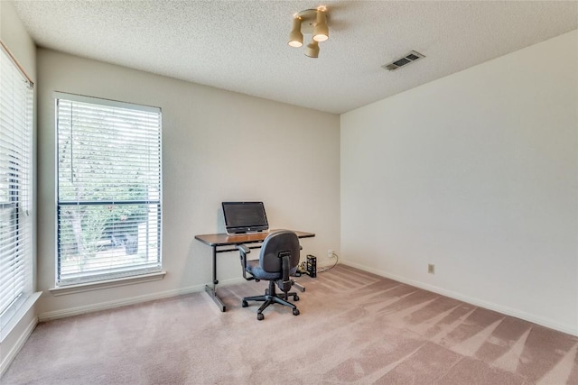 carpeted home office with a textured ceiling