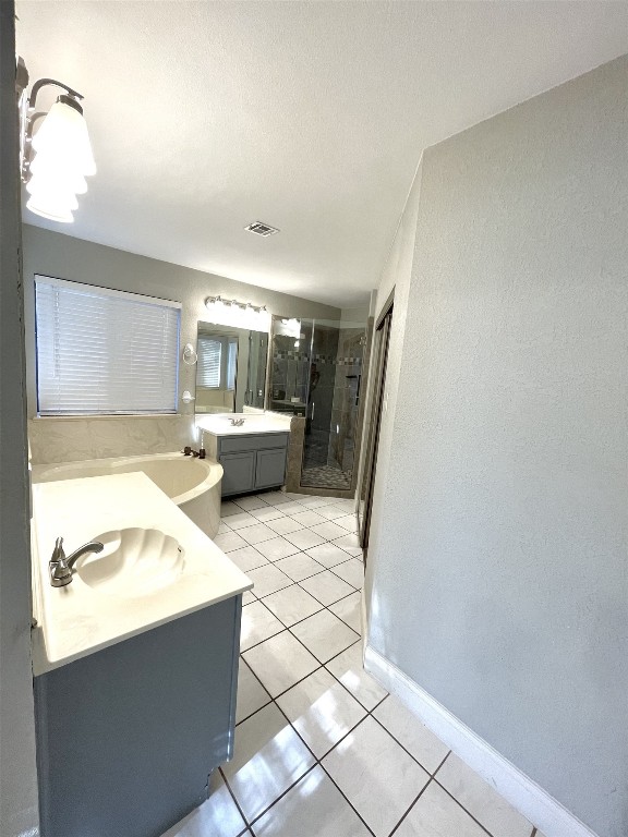 bathroom featuring tile patterned floors, separate shower and tub, vanity, and a textured ceiling