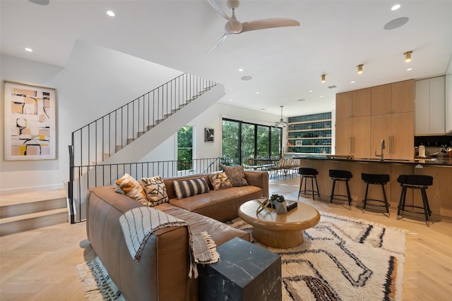 living room with ceiling fan, sink, and light parquet floors