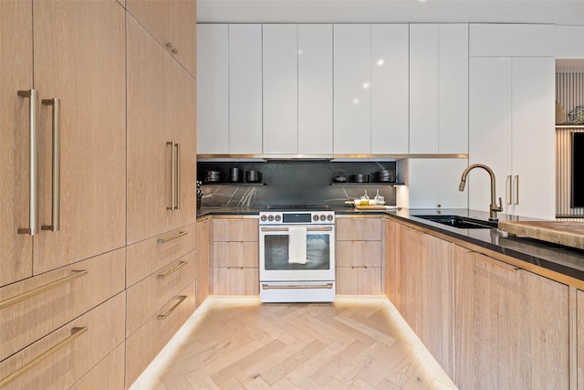 kitchen featuring electric stove, light brown cabinetry, sink, and light parquet floors