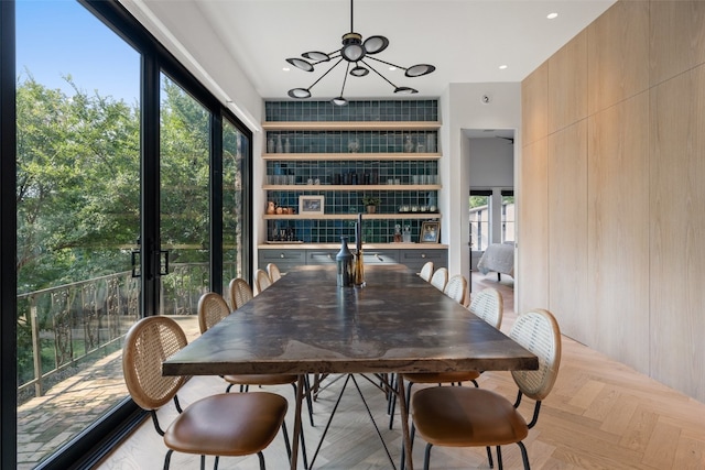 dining space featuring a chandelier, light parquet floors, and sink