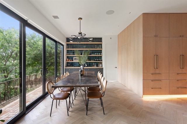 dining area with wooden walls and light parquet floors