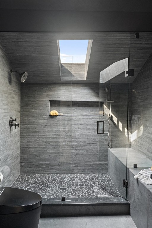 bathroom with toilet, a skylight, and an enclosed shower