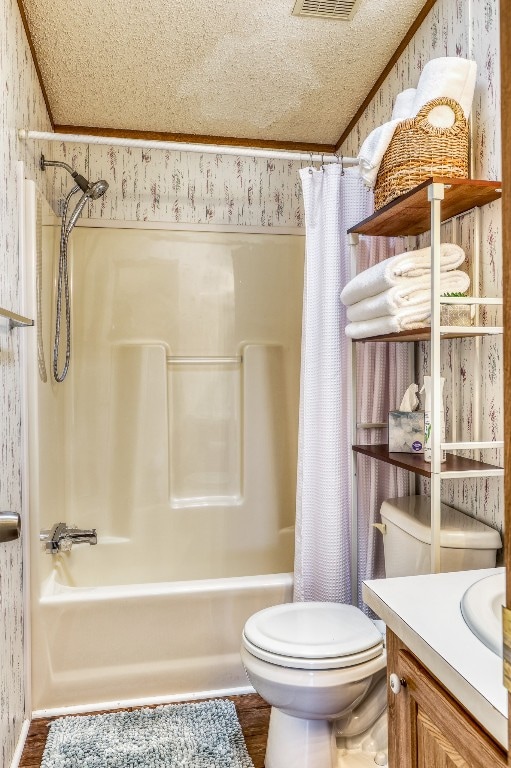 full bathroom featuring shower / bath combo, a textured ceiling, vanity, and toilet