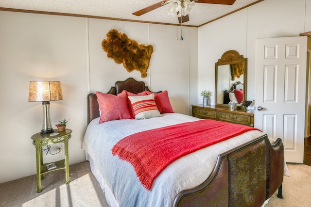 carpeted bedroom with a textured ceiling, crown molding, and ceiling fan