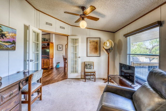 living room featuring ceiling fan, lofted ceiling, french doors, wood-type flooring, and a textured ceiling