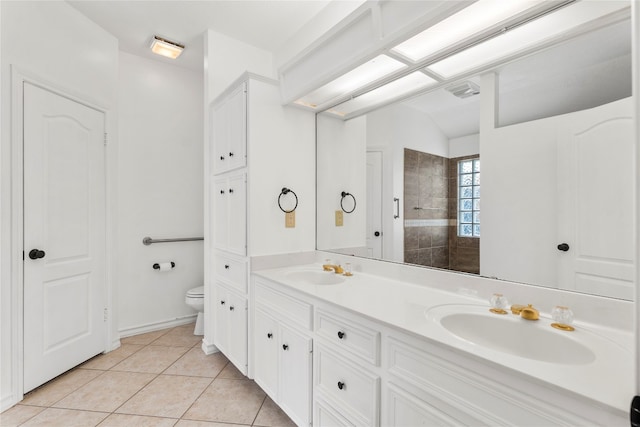 bathroom with a tile shower, tile patterned floors, vanity, and toilet