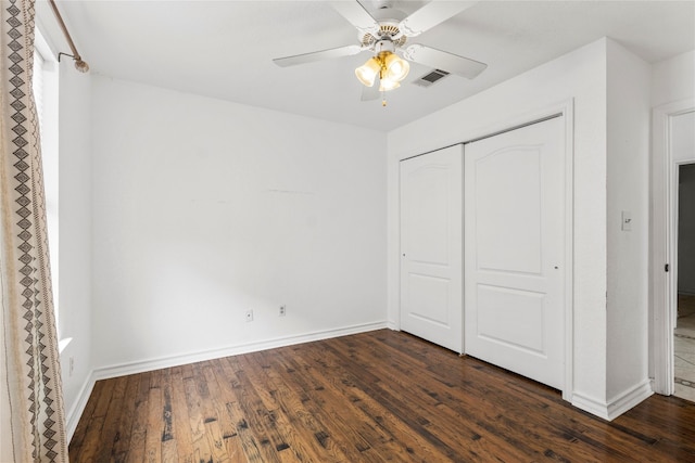 unfurnished bedroom featuring ceiling fan, dark wood-type flooring, and a closet