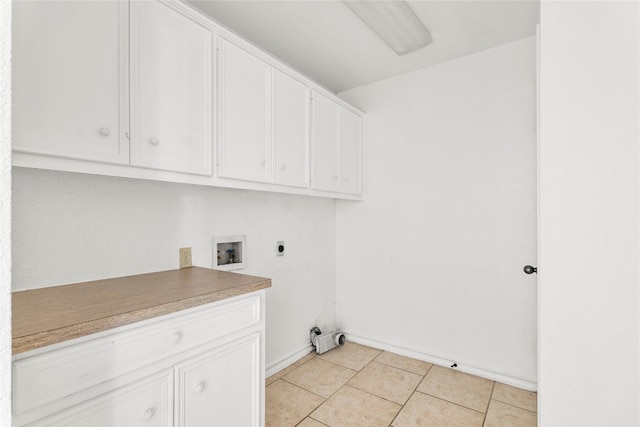 washroom with cabinets, hookup for an electric dryer, hookup for a washing machine, and light tile patterned floors