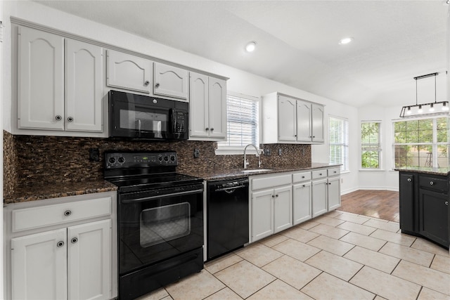 kitchen with white cabinets, lofted ceiling, hanging light fixtures, decorative backsplash, and black appliances