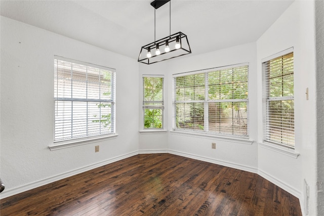 unfurnished dining area with a wealth of natural light and dark hardwood / wood-style floors