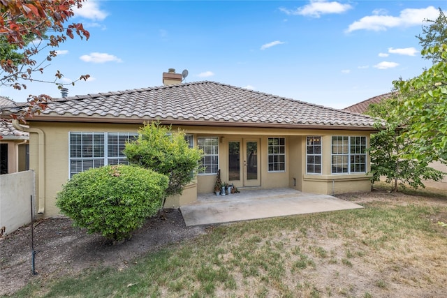 back of property featuring a patio and a yard