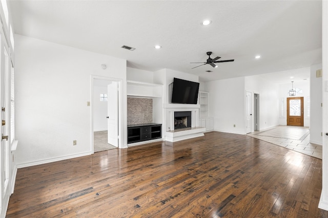 unfurnished living room featuring a large fireplace, ceiling fan, and hardwood / wood-style floors