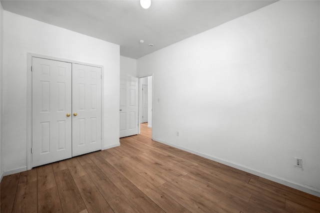 unfurnished bedroom featuring light hardwood / wood-style flooring and a closet