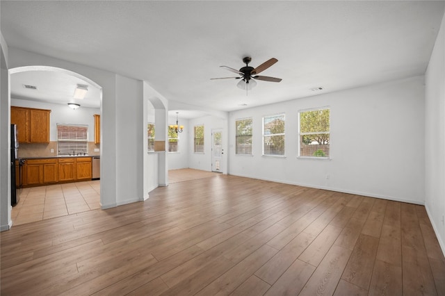 unfurnished living room with ceiling fan and light hardwood / wood-style floors