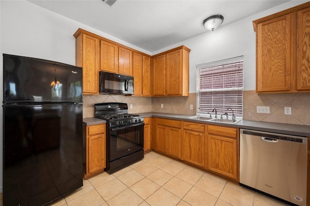 kitchen featuring a sink, light tile patterned flooring, decorative backsplash, black appliances, and brown cabinetry