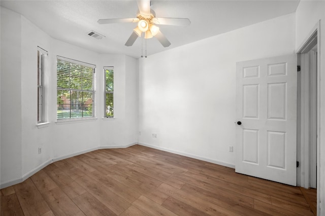 empty room with hardwood / wood-style floors and ceiling fan