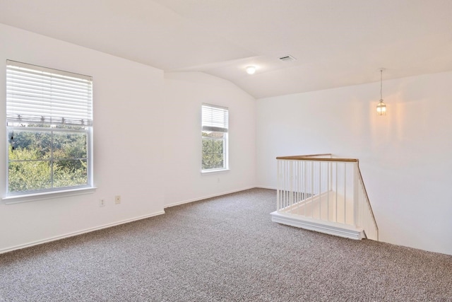 carpeted spare room featuring lofted ceiling