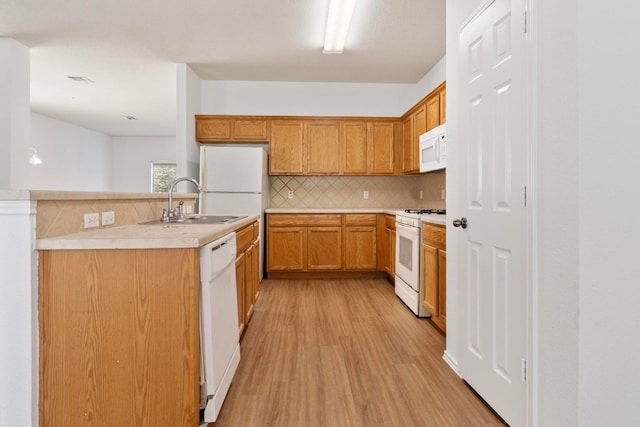 kitchen featuring light wood-type flooring, white appliances, sink, and tasteful backsplash