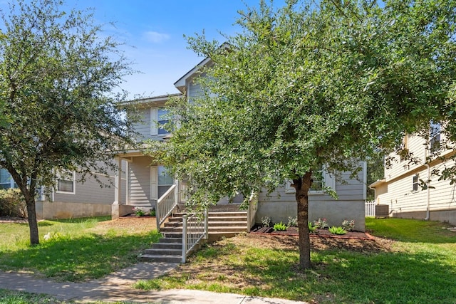 obstructed view of property featuring cooling unit and a front lawn