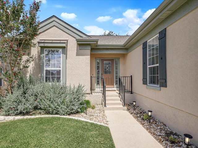 view of exterior entry featuring a yard