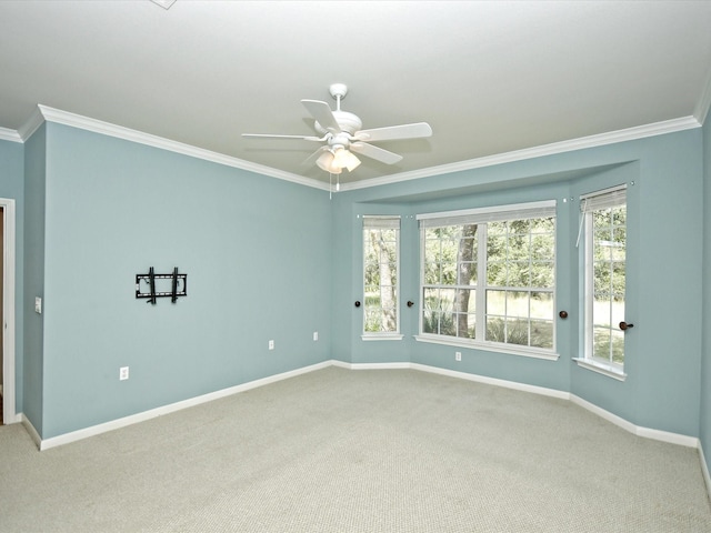 carpeted empty room with ceiling fan, ornamental molding, and plenty of natural light