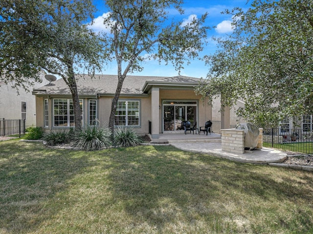 rear view of property with a yard and a patio area