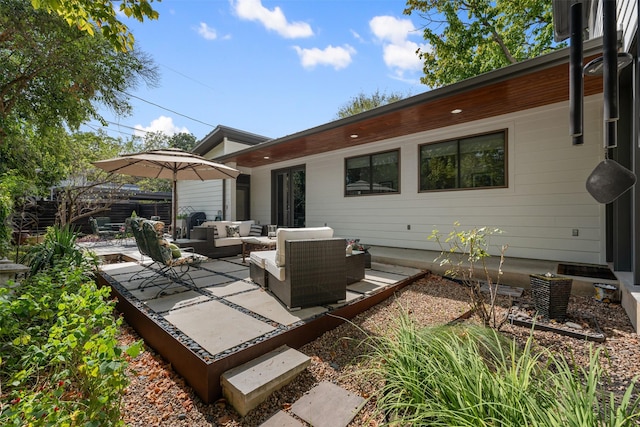 rear view of house featuring an outdoor living space and a patio