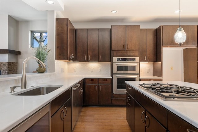 711 W Live Oak St, Austin, TX 78704 - kitchen featuring a sink, stainless steel appliances, light countertops, light wood finished floors, and recessed lighting
