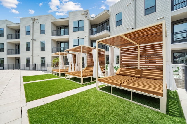 back of property featuring a balcony and a yard