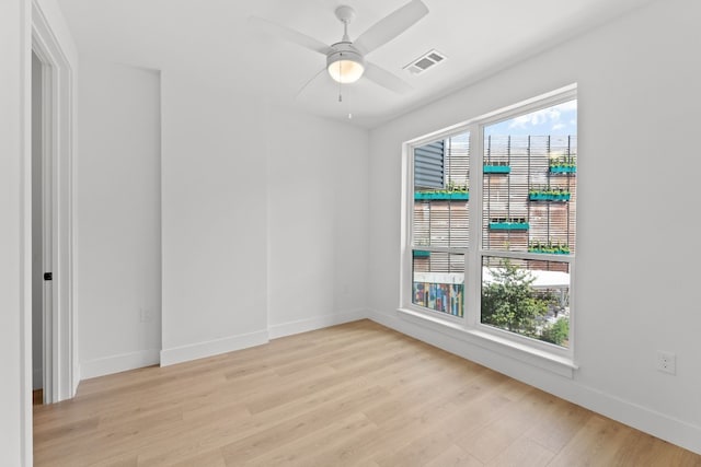 spare room with ceiling fan, light hardwood / wood-style flooring, and a wealth of natural light