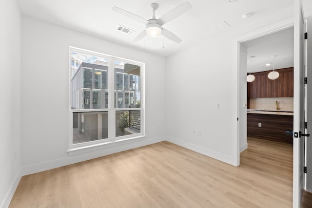 unfurnished room featuring light wood-type flooring and ceiling fan