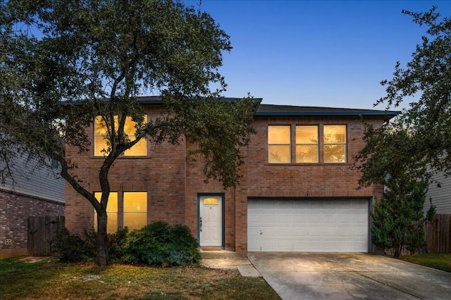 traditional-style house with an attached garage, driveway, fence, and brick siding