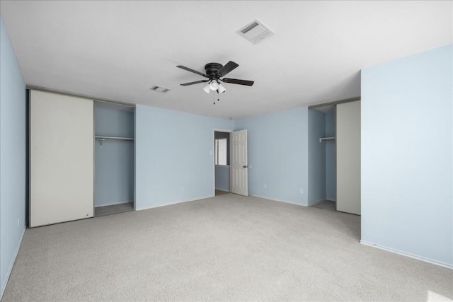 unfurnished bedroom with visible vents, a ceiling fan, and light colored carpet