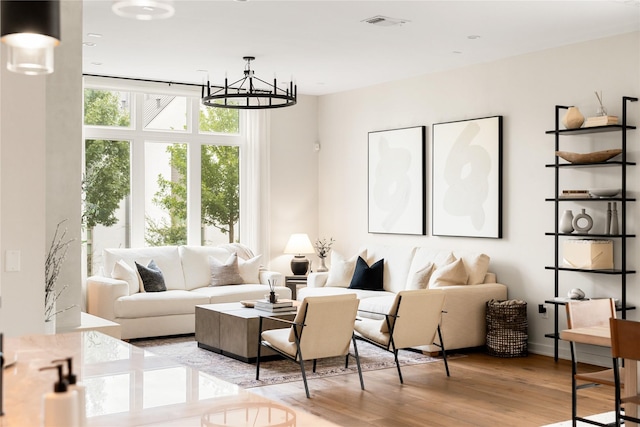 living room featuring a notable chandelier and light hardwood / wood-style floors