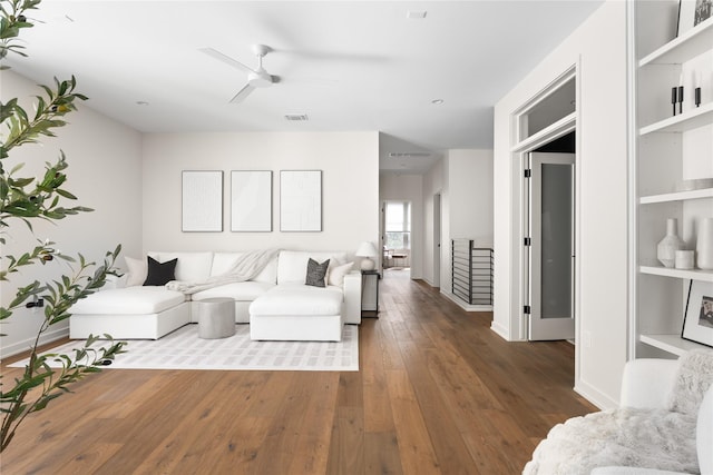 living room featuring dark wood-type flooring and ceiling fan