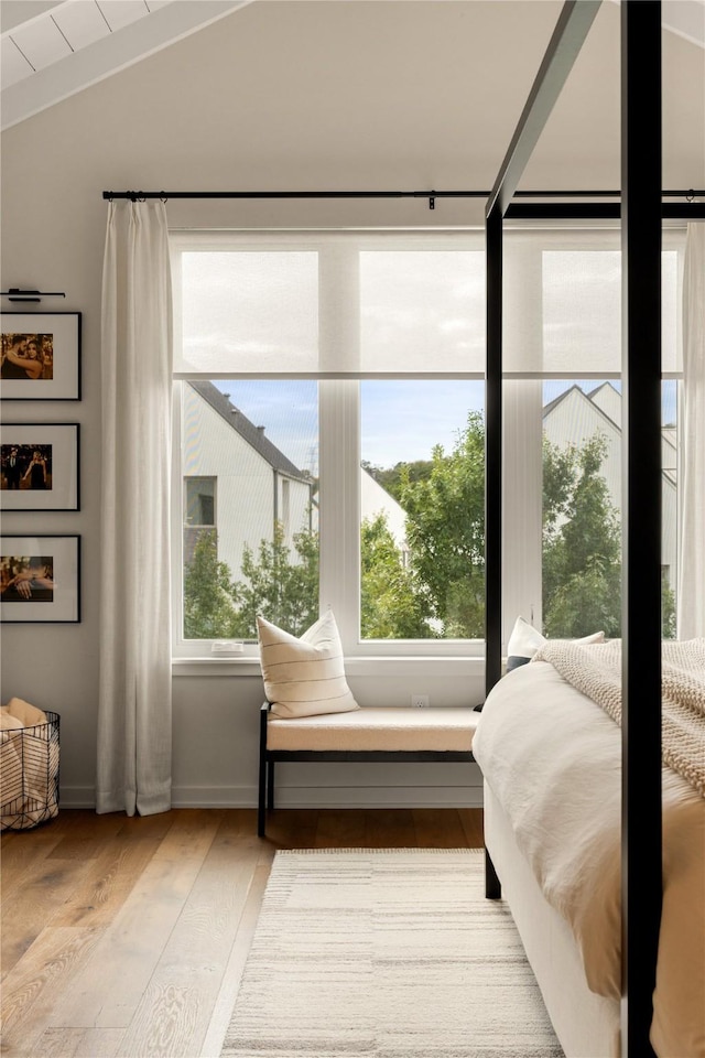 bedroom with lofted ceiling and light wood-type flooring