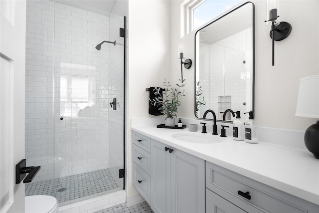 bathroom featuring vanity, an enclosed shower, and toilet