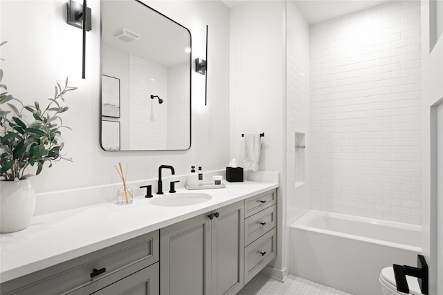 full bathroom featuring tile patterned floors, vanity, toilet, and tiled shower / bath combo