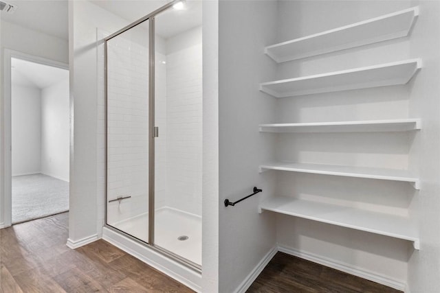 bathroom featuring wood-type flooring and a shower with door