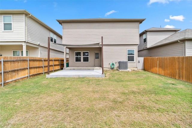 rear view of property featuring a yard, central AC, and a patio area