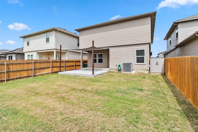 rear view of property featuring cooling unit, a patio area, and a lawn