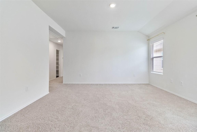 carpeted empty room with lofted ceiling