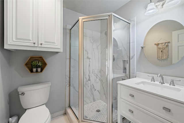 bathroom featuring a shower with door, toilet, and vanity