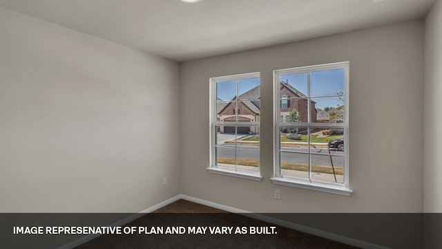 empty room with plenty of natural light and carpet flooring