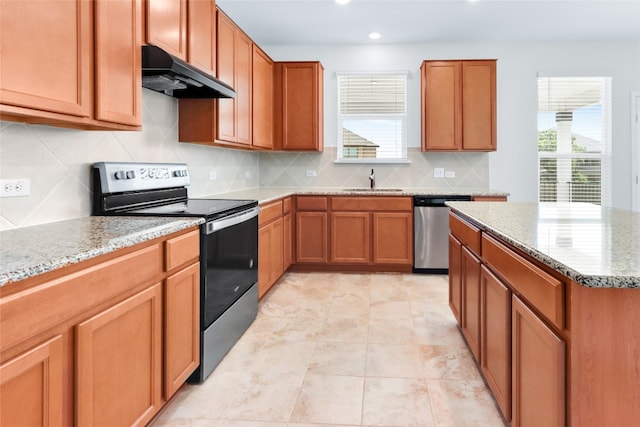 kitchen featuring light stone counters, sink, decorative backsplash, stainless steel appliances, and light tile patterned floors