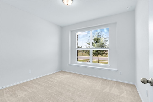 spare room featuring light colored carpet