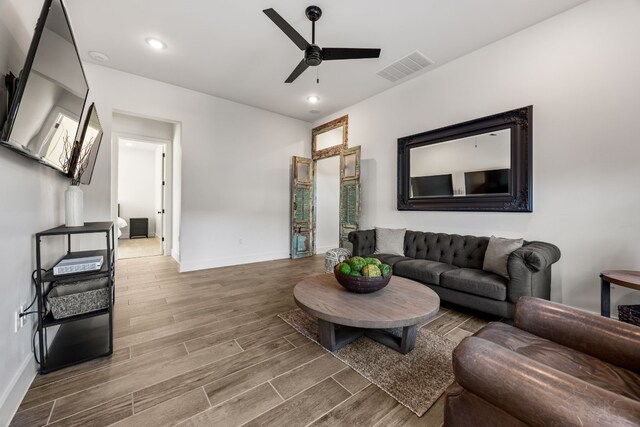 living room featuring hardwood / wood-style floors and ceiling fan