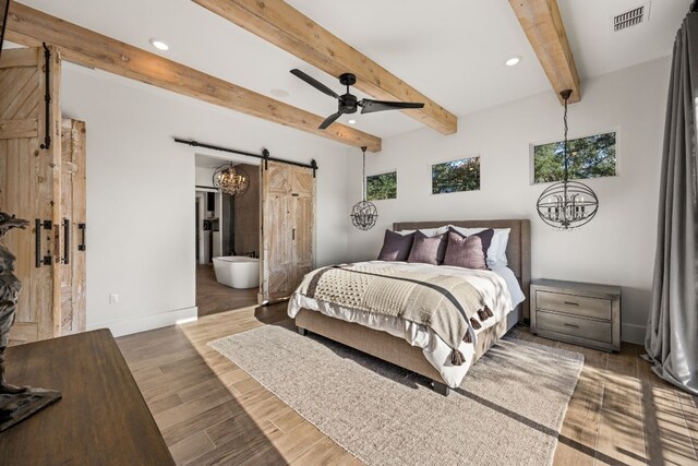 bedroom featuring dark hardwood / wood-style flooring, beam ceiling, ceiling fan with notable chandelier, and a barn door