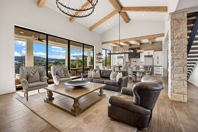 living room with a healthy amount of sunlight, light hardwood / wood-style floors, and an inviting chandelier